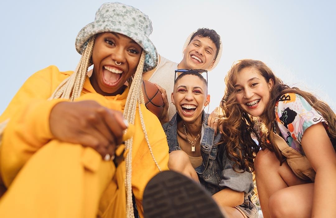 a group of young people smilling at the camera together posing for a photo