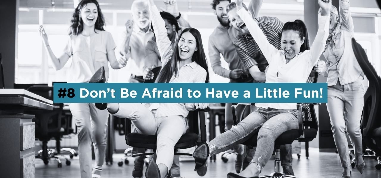 Group of coworkers laughing and celebrating in an office, representing fun and engaging brand personality in marketing.
